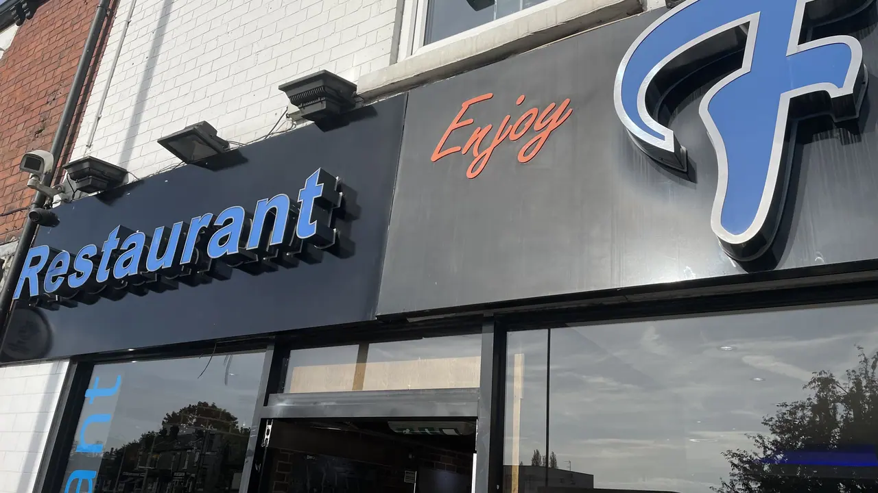Black restaurant fascia with blue illuminated lettering