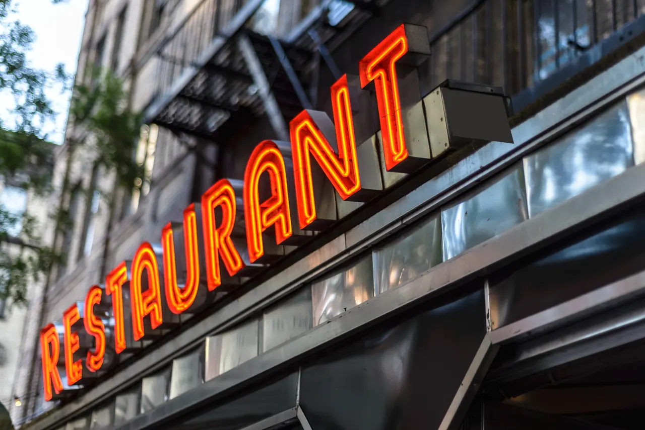 Orange neon RESTAURANT sign outside a building