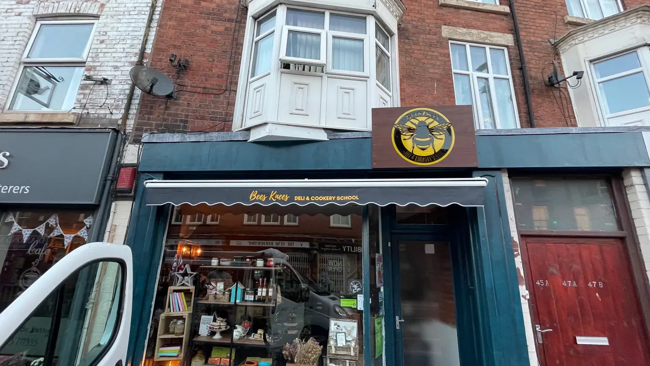 Dark blue shop front with signage and awning